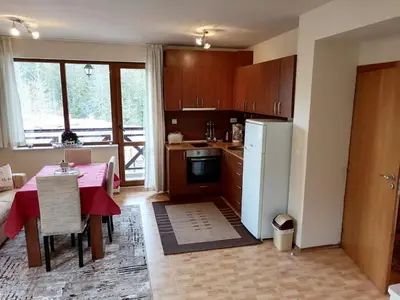 a kitchen with a table and a white refrigerator at Apartment Dream Pamporovo in Pamporovo