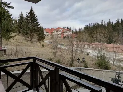 a view of a house from a wooden balcony at Apartment Dream Pamporovo in Pamporovo