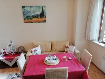 a dining room with a red table and a couch at Apartment Dream Pamporovo in Pamporovo
