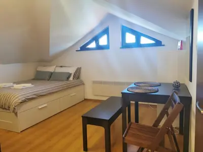 a bedroom with a bed and a table with a chair at Pirin and Bansko view Studio in Bansko