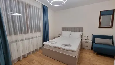 a small bedroom with a bed and a blue chair at Guest House Gogemi in Bansko