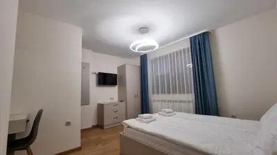 a bedroom with a bed and a desk and a window at Guest House Gogemi in Bansko