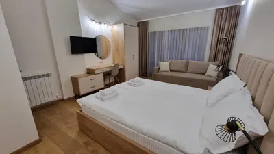 a bedroom with a white bed and a couch at Guest House Gogemi in Bansko