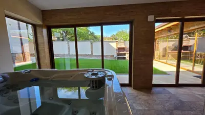 a bath tub in a house with a view of a yard at Guest House Gogemi in Bansko