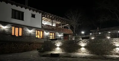 a building with lights on the side of it at night at Vladimirov's House Kovachevitsa , Цяла къща in Kovachevitsa