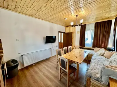 a living room with a table and a couch at Къща за гости “Александър” in Velingrad