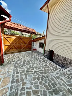 a stone patio with a wooden gate and a building at Къща за гости “Александър” in Velingrad