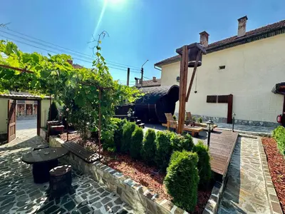 a garden with a bench next to a building at Къща за гости “Александър” in Velingrad