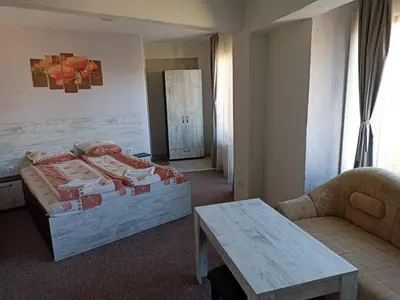 a bedroom with a bed and a table and a couch at Petar Guest House in Bansko