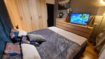 a bedroom with a bed and a flat screen tv at Apartmanica Double room apartment 101-12, with AC, big terrace, St Ivan Rilski 4 star SPA Resort, Bansko in Bansko