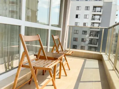 two wooden chairs sitting on a balcony at Elite Business Residence with Free Gym Pass, Street Parking and Full Office Setup in Plovdiv
