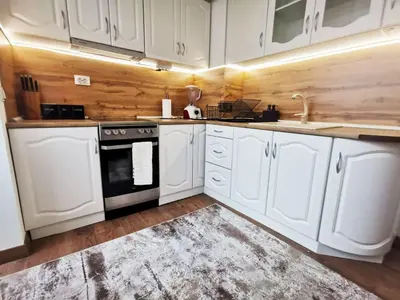 a kitchen with white cabinets and a sink and a stove at Central Apartment near the Park in Gotse Delchev