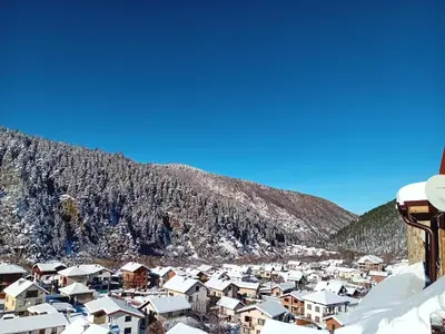 a town covered in snow with a mountain in the background at Studio apartment with mountain view at Eagle Rock complex in Beli Iskar