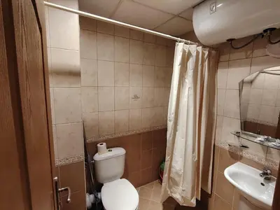 a small bathroom with a toilet and a sink at Studio apartment with mountain view at Eagle Rock complex in Beli Iskar