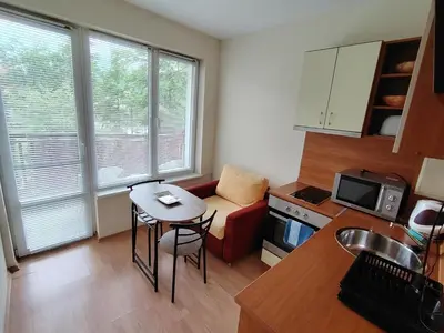 a small kitchen with a small table and a couch at Studio apartment with mountain view at Eagle Rock complex in Beli Iskar