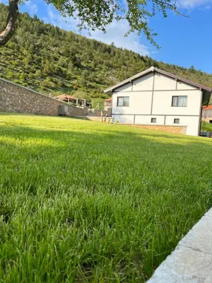 a large field of grass with a building in the background at Вила ИГЛИКА in Yagodina