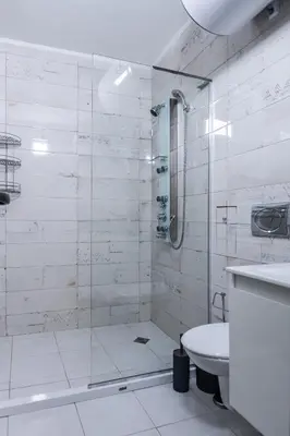 a white bathroom with a shower and a toilet at Intelligent Elephant Home - 1BDR Apartment by Flat Mаnager in Sofia