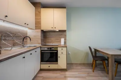 a kitchen with white cabinets and a wooden table at Intelligent Elephant Home - 1BDR Apartment by Flat Mаnager in Sofia