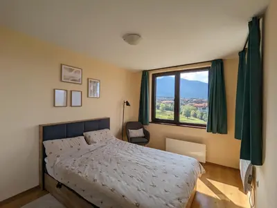 a bedroom with a bed and a large window at Stylish 2BD Apartment with Panoramic Mountain View by Flat Mаnager in Bansko