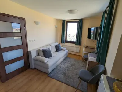 a living room with a couch and a television at Stylish 2BD Apartment with Panoramic Mountain View by Flat Mаnager in Bansko
