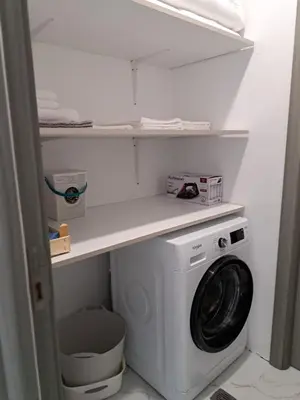 a laundry room with a washing machine and a shelf at Sunset view guest house in Ilindentsi