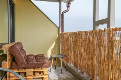 a chair and a table on a balcony at Panoramic Terrace City View Suite in Sofia Center in Sofia