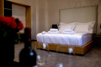 a bedroom with a bed with white sheets and pillows at Hotel CITY Sandanski in Sandanski
