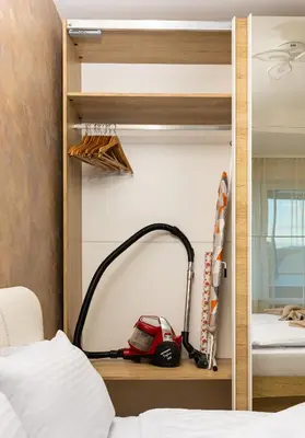 a bedroom with a vacuum cleaner on a shelf next to a bed at Sunny 1BD Apartment in OLD TOWN by Flat Mаnager in Plovdiv