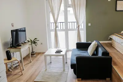 a living room with a couch and a tv at Stylish apartment, very good location! in Sofia