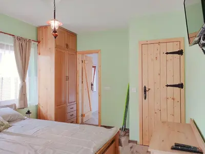 a bedroom with a bed and a wooden door at Villa Tangra in Grashtitsa