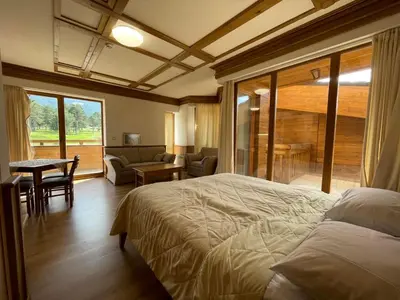 a bedroom with a large bed and a living room at Pirin Golf SPA Studio Mountain View Compass Property in Bansko