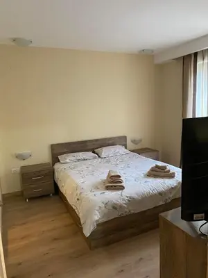 a bedroom with a bed with towels on it at Grand Apartments in Bansko