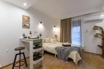 a bedroom with a bed and a table and a window at Ski&Stay Studio Bansko in Bansko