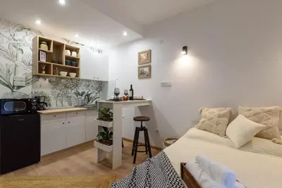 a bedroom with a bed and a small kitchen at Ski&Stay Studio Bansko in Bansko