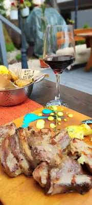 a wooden cutting board with a glass of wine and meat at Belvedere Holiday Club К302 in Bansko