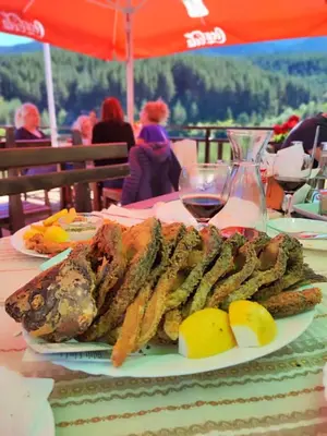 a plate of food on a table with a glass of wine at Belvedere Holiday Club К302 in Bansko