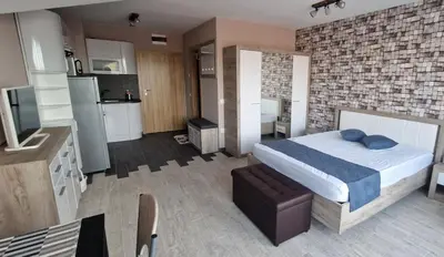 a bedroom with a large bed and a kitchen at B55 Studio in Borovets