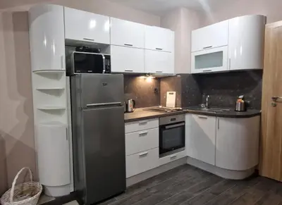 a kitchen with white cabinets and a stainless steel refrigerator at B55 Studio in Borovets