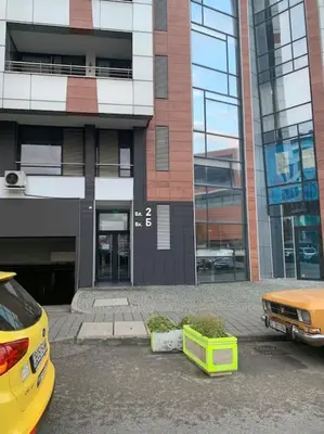 a yellow car parked in front of a building at SliverCity next to paradise mall in Sofia