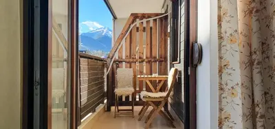 a balcony with two chairs and a view of a mountain at Gondola Ski Lift Apartment in Bansko