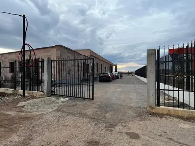 a gate with cars parked in a parking lot at Elegant and cozy room ARAKS in Kostinbrod