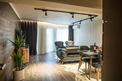 a living room with a couch and a table and chairs at Lux Apart Karlovo in Karlovo