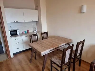 a kitchen with a wooden table and chairs in a room at Suite Roma 2 at Spa Club Bor in Velingrad