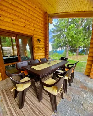 a wooden dining room with a table and chairs at Вила Брезите in Pamporovo