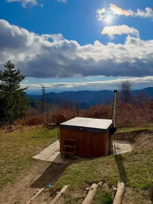 a wooden shed with a chair in a field at Вила Брезите in Pamporovo