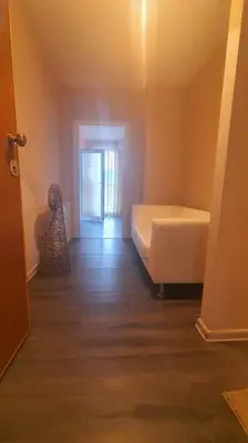 a room with a bed and a hallway with a door at Елегантен градски апартамент с обширна тераса in Pernik