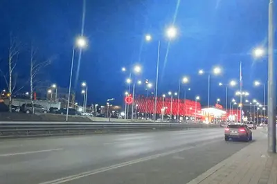 a car driving down a street at night with street lights at Елегантен градски апартамент с обширна тераса in Pernik