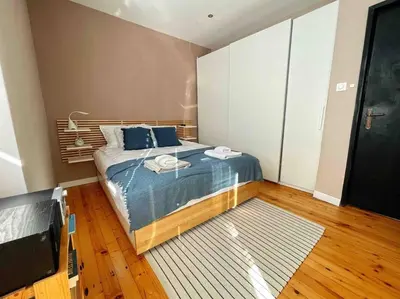 a bedroom with a bed with blue sheets and blue pillows at Cozy & Boho Top Center Apartment in Sofia
