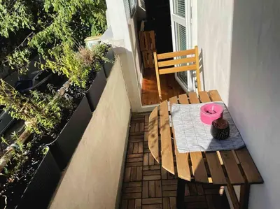 a wooden table with a pink plate on it on a balcony at Cozy & Boho Top Center Apartment in Sofia