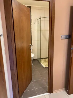 a bathroom with a toilet and a glass door at Апартамент за гости Свети Трифон in Pamporovo